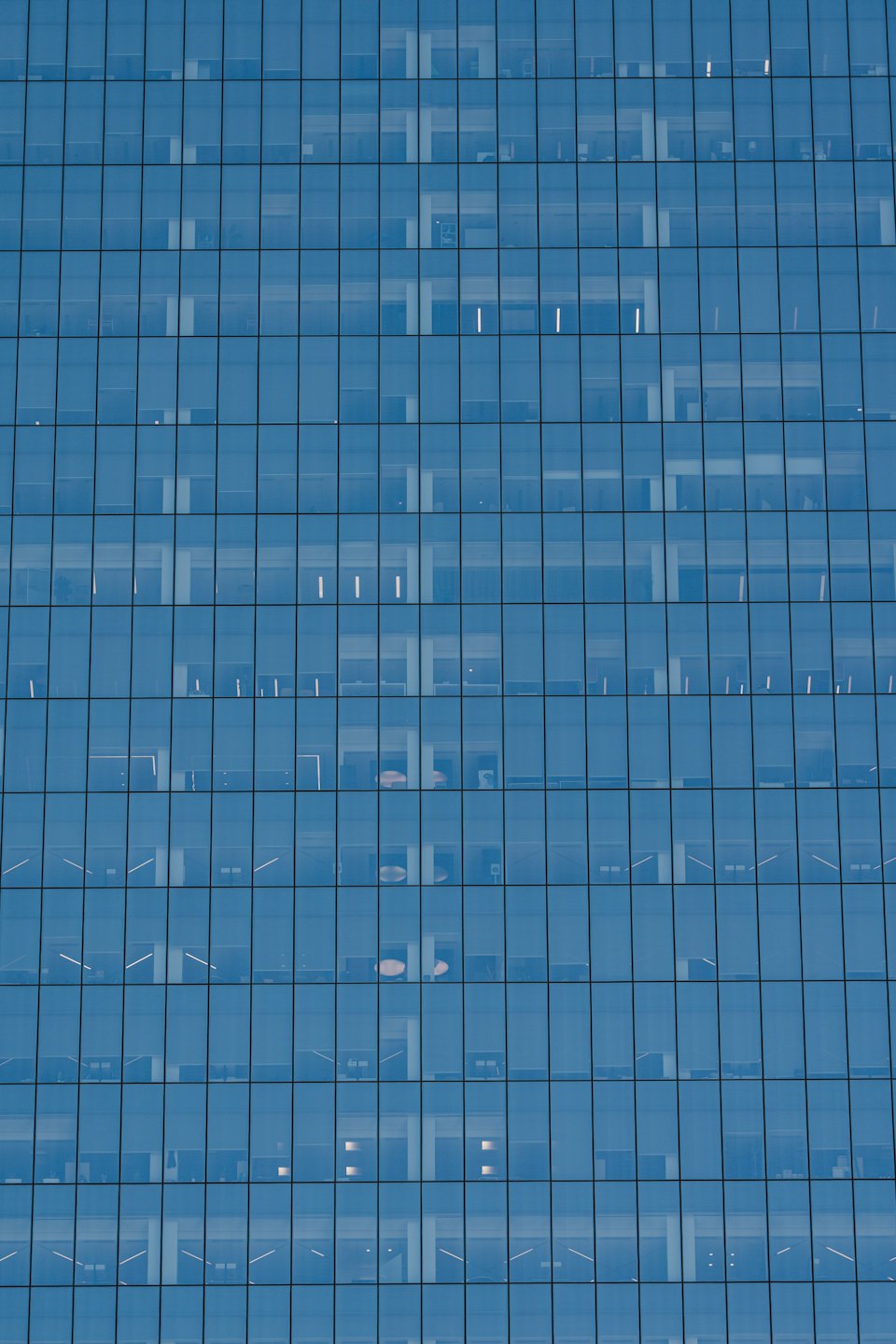 Modern office building with a reflective glass grid facade.